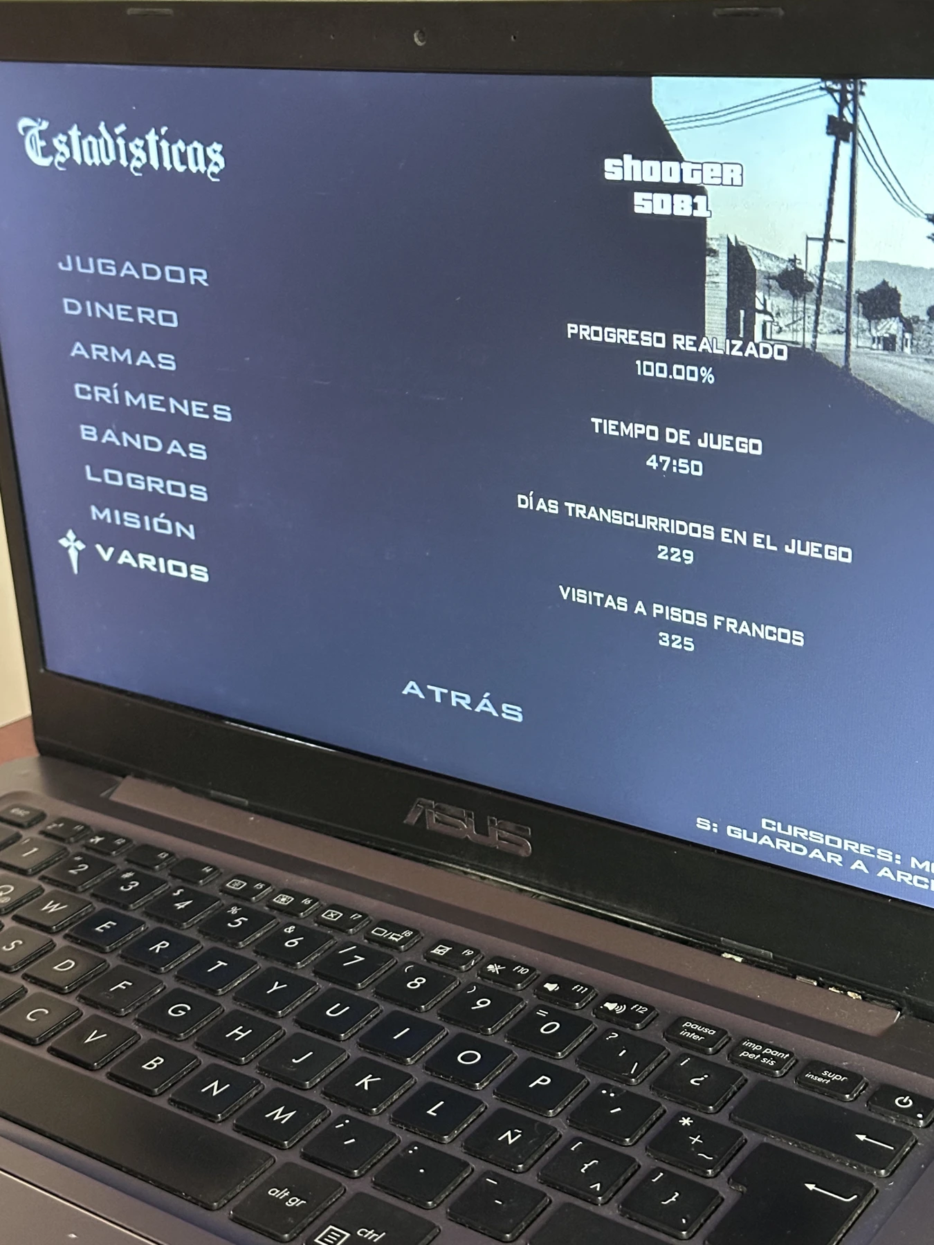 Foto vertical de la pantalla y teclado de mi laptop con el progreso del juego al 100 por ciento